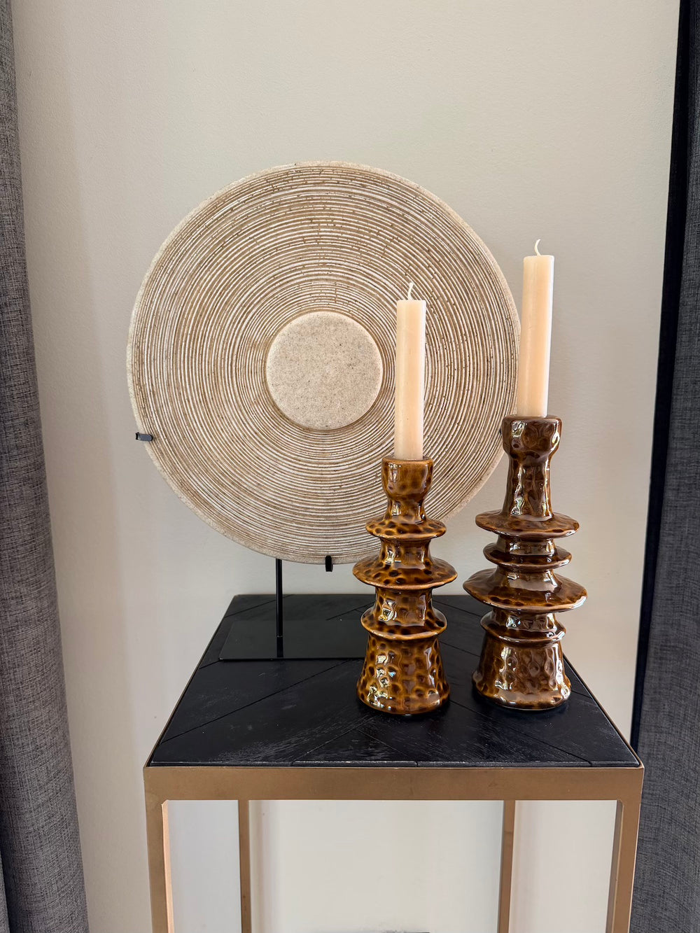 Zandstenen decoratie op standaard gecombineerd met twee bruine kandelaars
