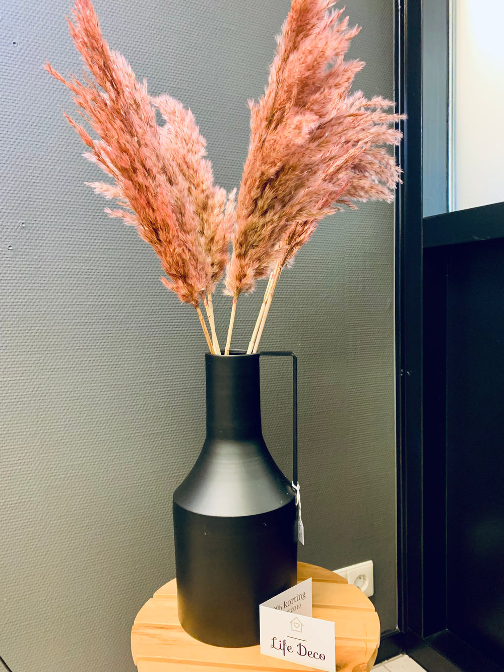 zwarte vaas met roze pluimen