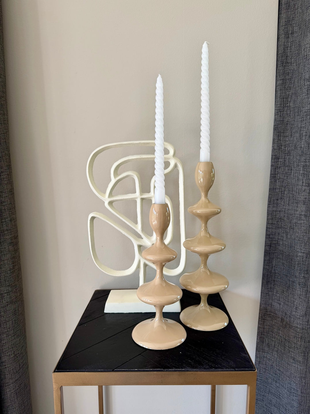 Kandelaar Vireen Sand set gestyled met witte dinerkaarsen en decoratief object op tafel