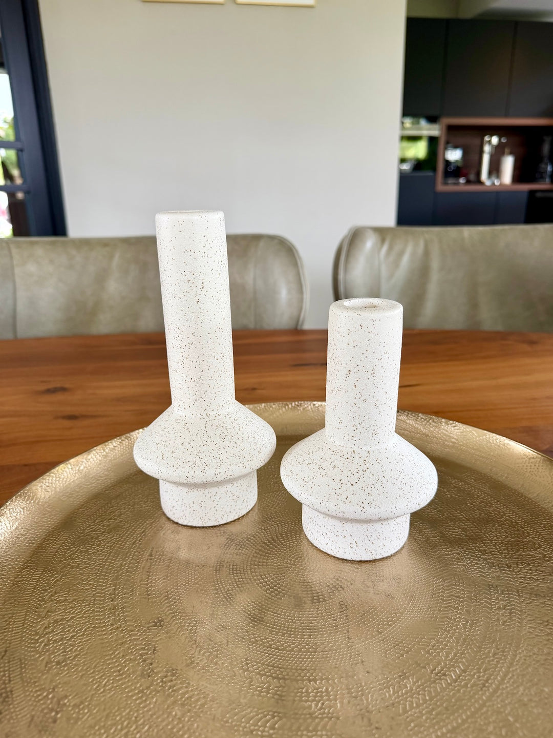 Moderne keramieken kandelaarset op gouden schaal in warm interieur