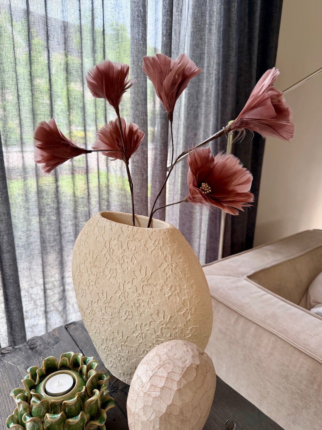 Warm modern interieur met blush kunsttakken, sculpturale vaas en stijlvolle woonaccessoire