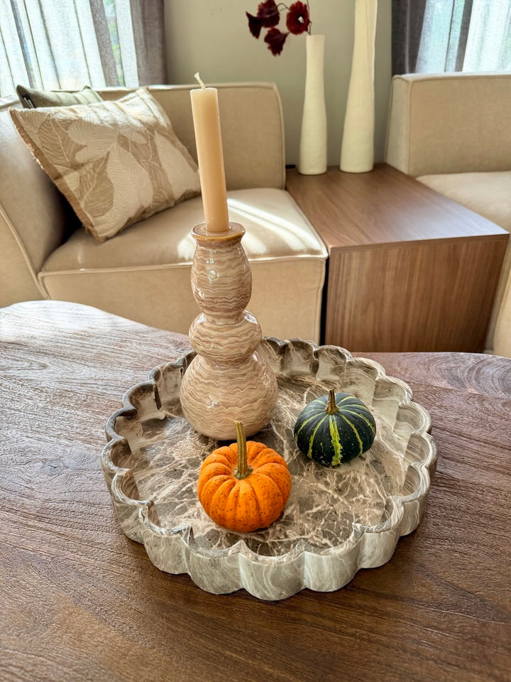 Zandkleurige kandelaar op een decoratieplateau met pompoenen