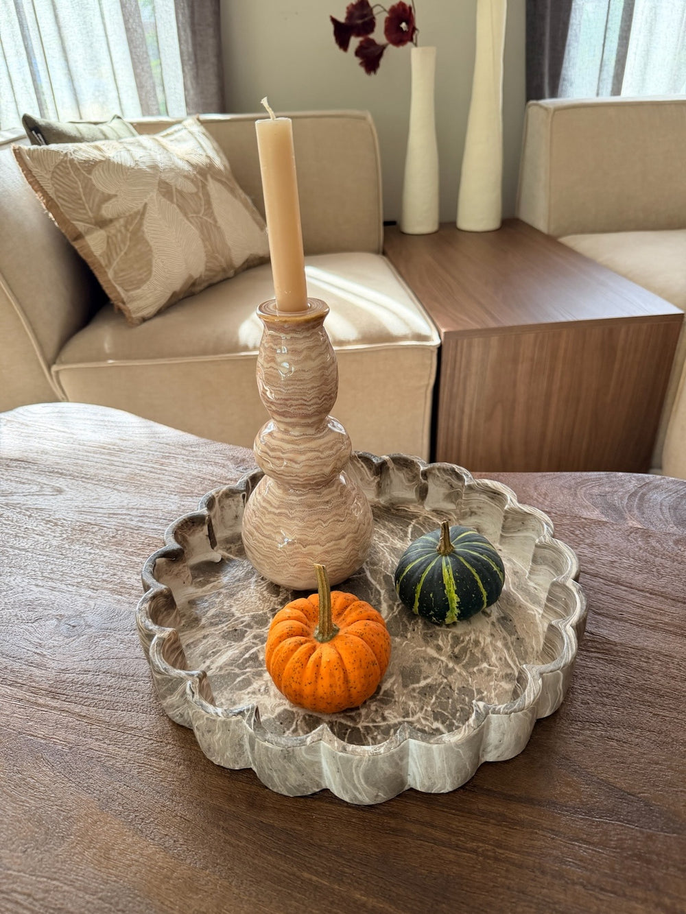 Bruin gemarmerd decoratieplateau met kandelaar en pompoenen op een houten tafel