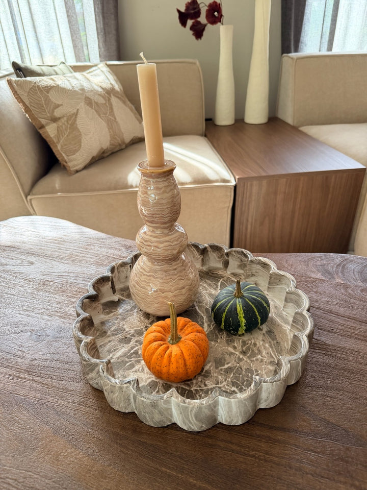 Bruin gemarmerd decoratieplateau met kandelaar en pompoenen op een houten tafel