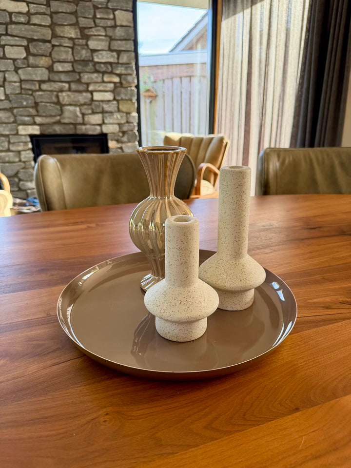 Taupe decoratieplateau gestyled met een vaas en zandkleurige kandelaars