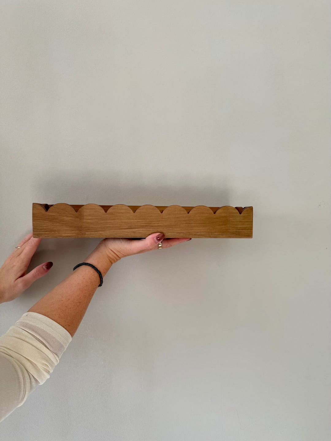 Vooraanzicht van bruine rubberhouten wandplank met golfrand